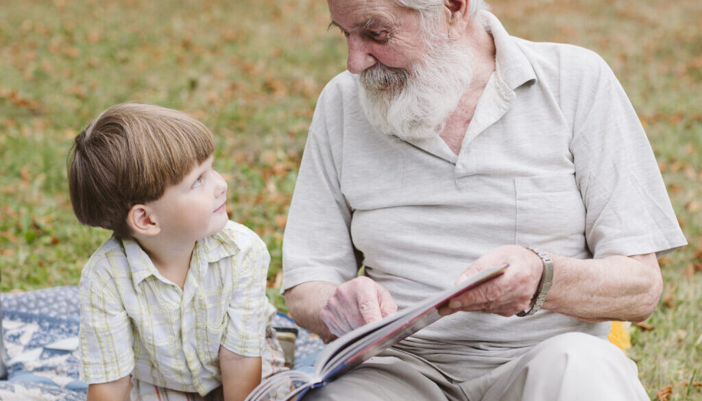 lettura-del-nonno-per-il-nipote-nel-parco